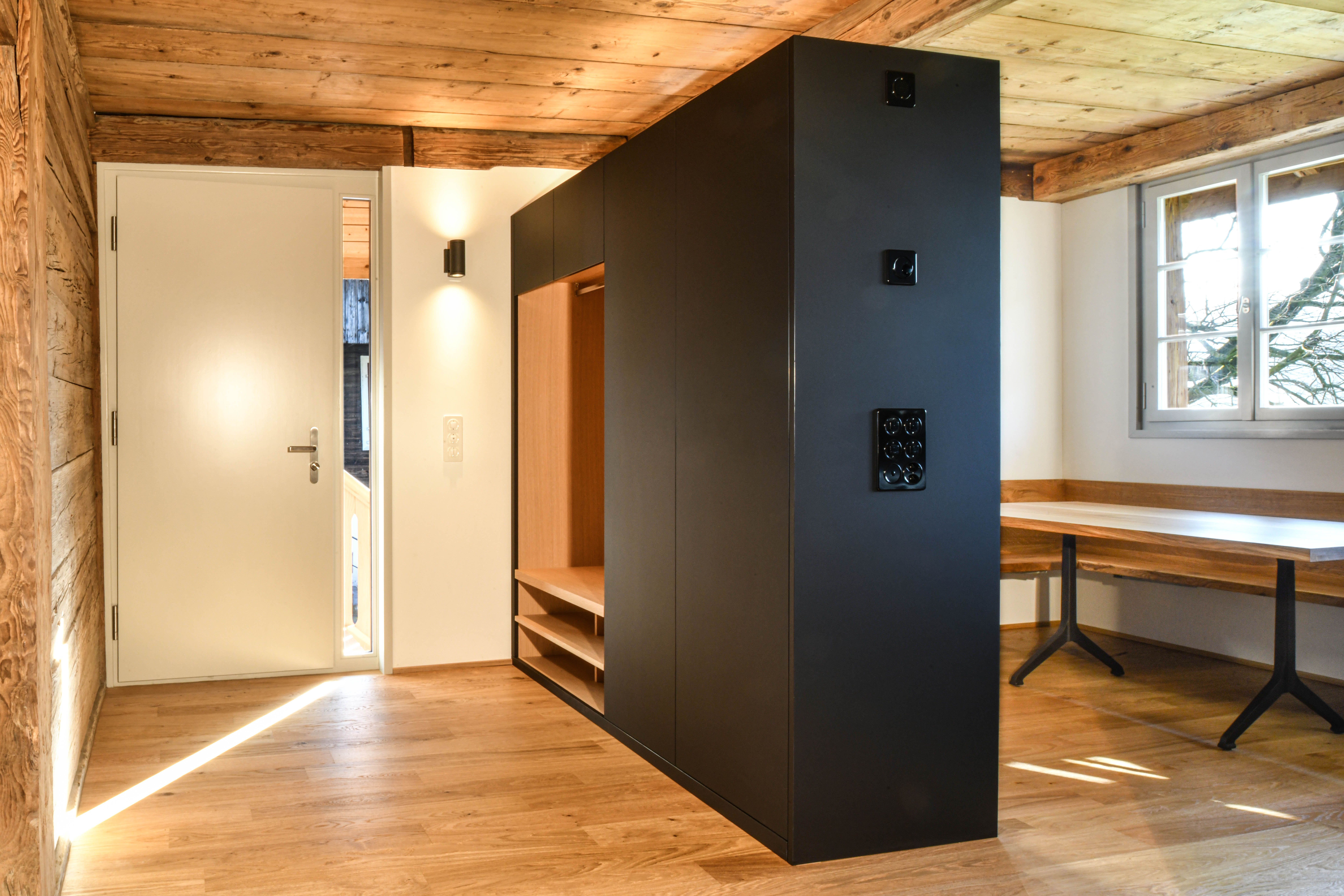 Wohnung im Hochparterre nach dem Umbau mit Tür, Tisch und Schrank in der Raummitte